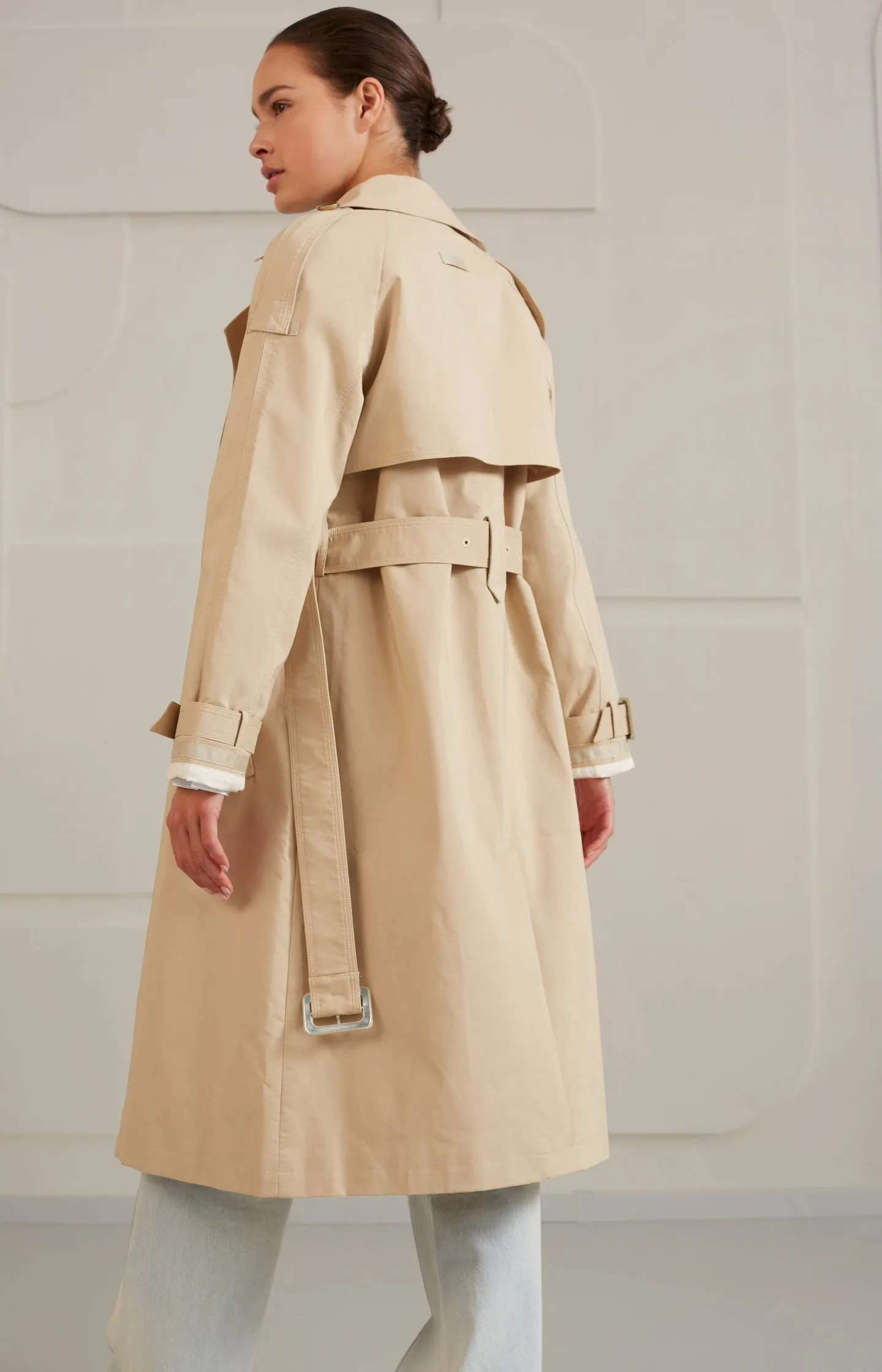 Double breasted trench coat with long sleeves, pockets and belt